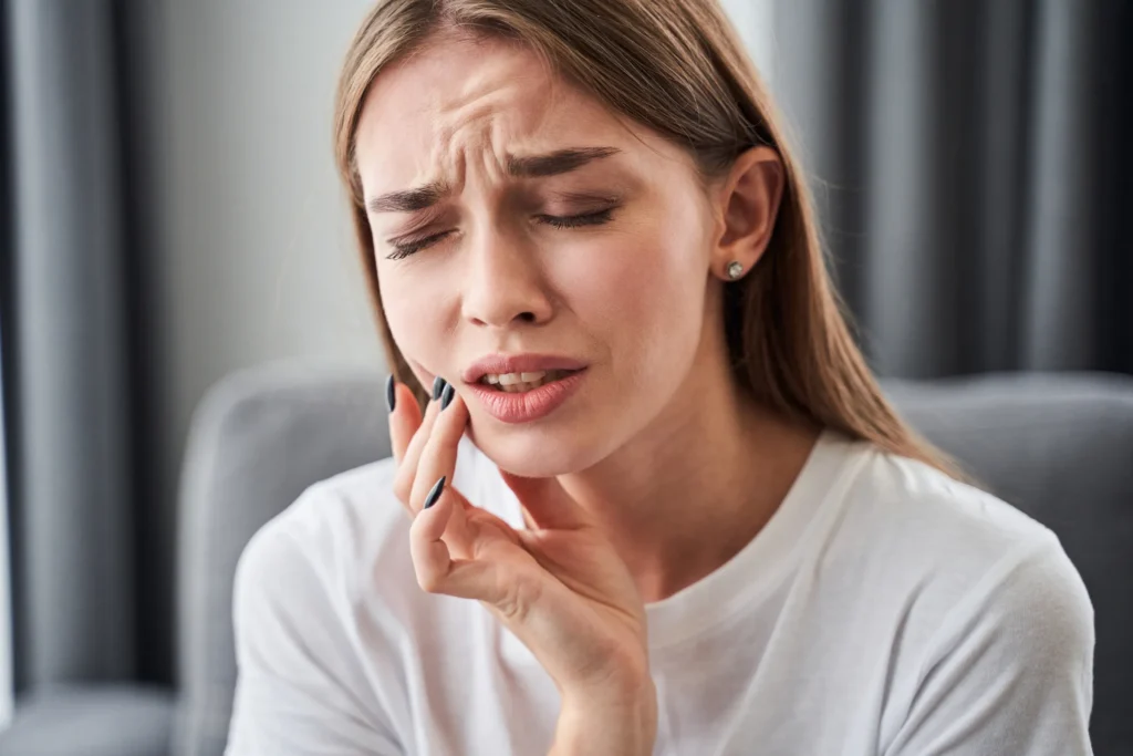 Woman holding her jaw in discomfort