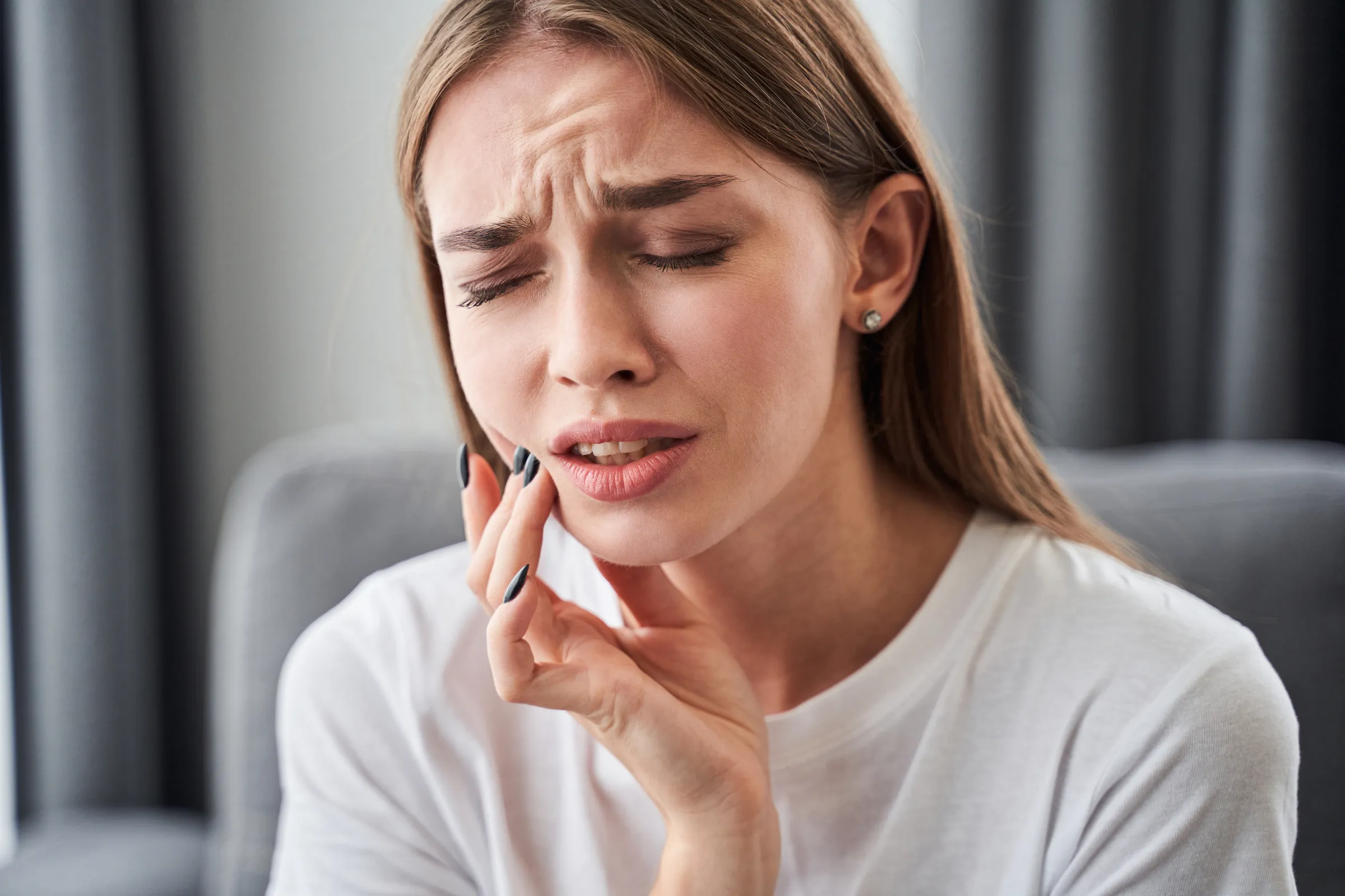 Woman holding her jaw in discomfort
