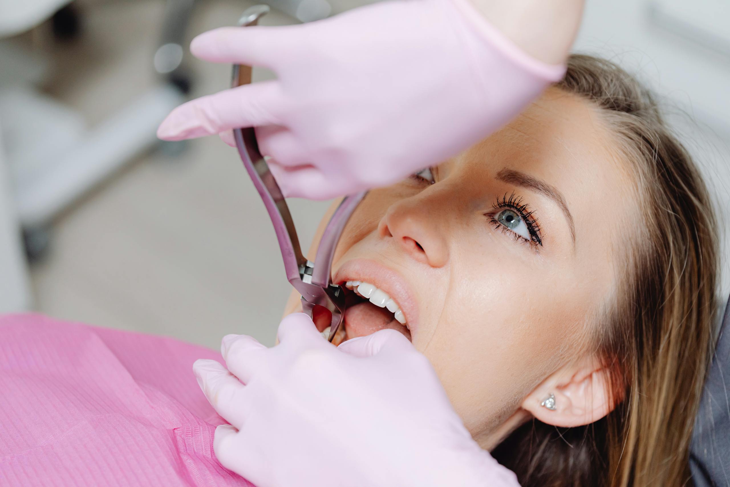 Dentist performing procedure on woman patient using dental tools. Close-up view.