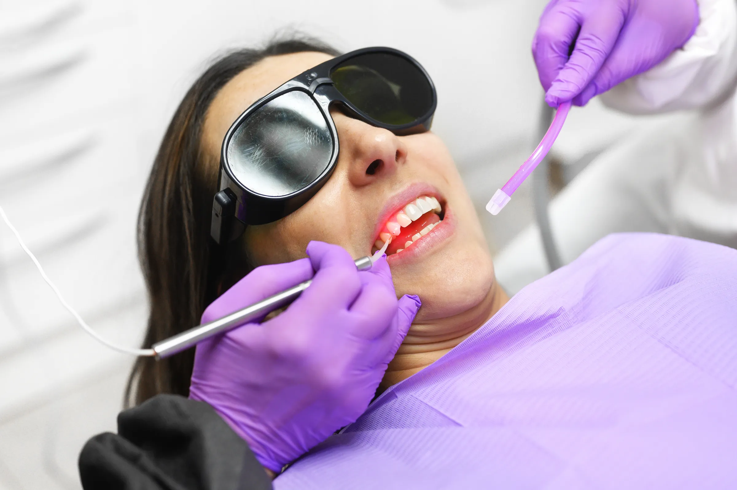 Patient in protective glasses during laser dental treatment
