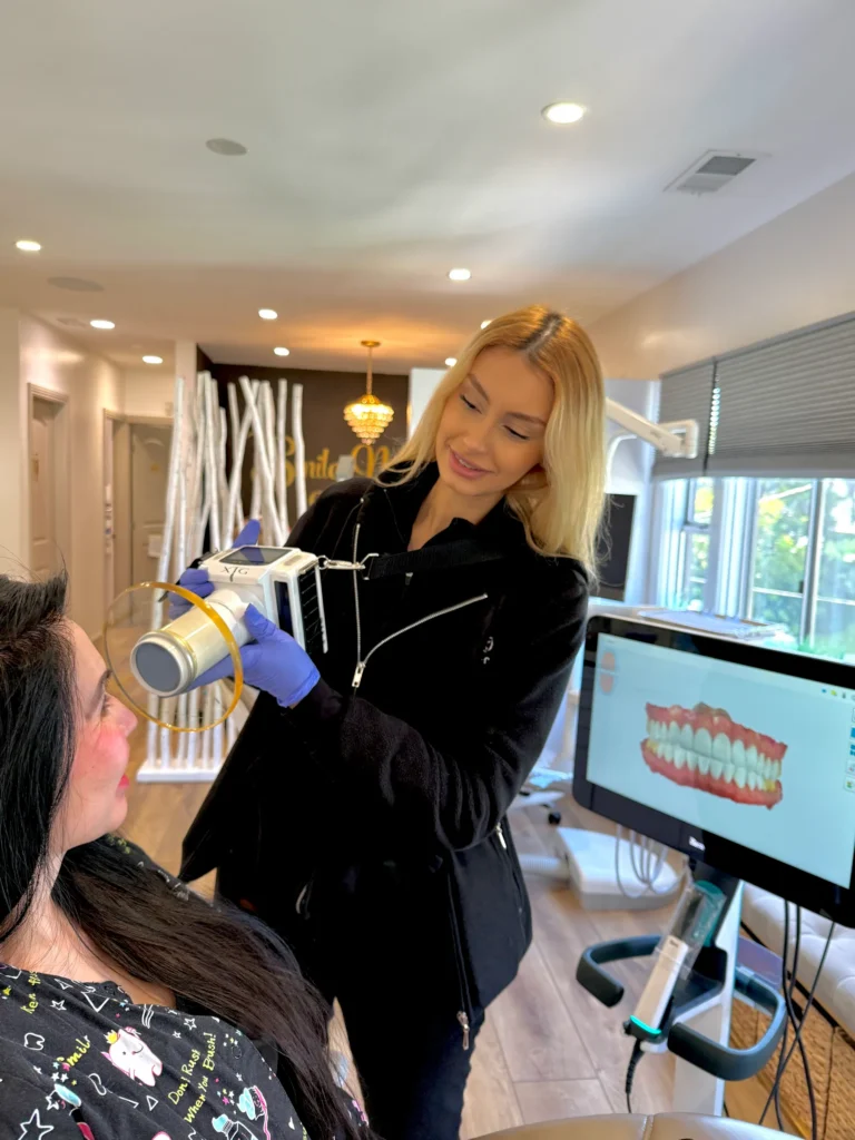 A team member with a patient, a digital model of teeth on screen